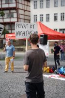 Protest 2020 in Gießen: eine Person hält ein Pappschild hoch »Privat ist nicht Gesund« im Hintergrund spricht jemand